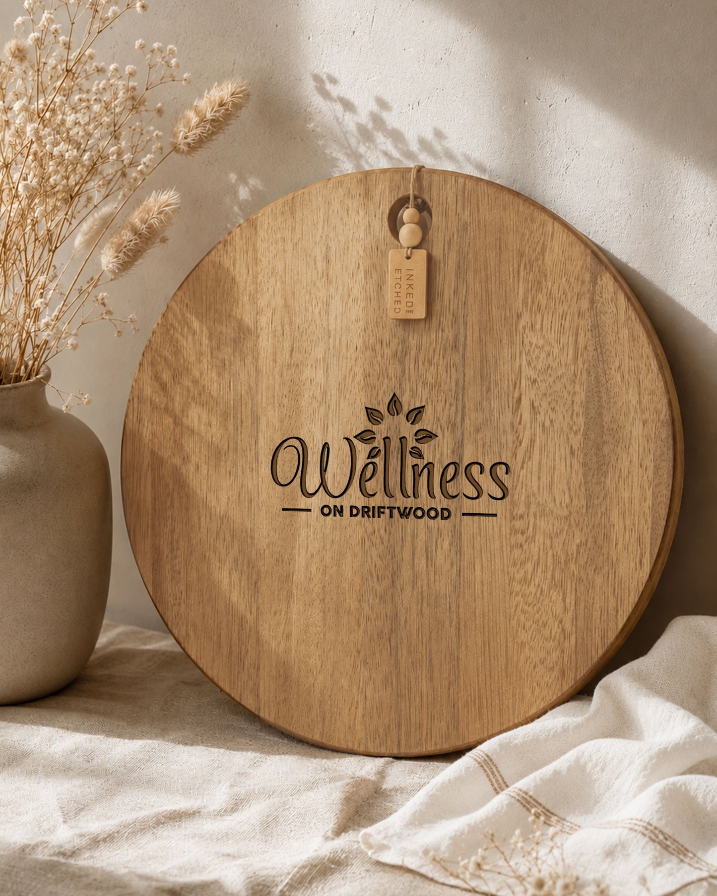 Branded acacia serving board engraved with a business logo, photographed in warm natural light.
