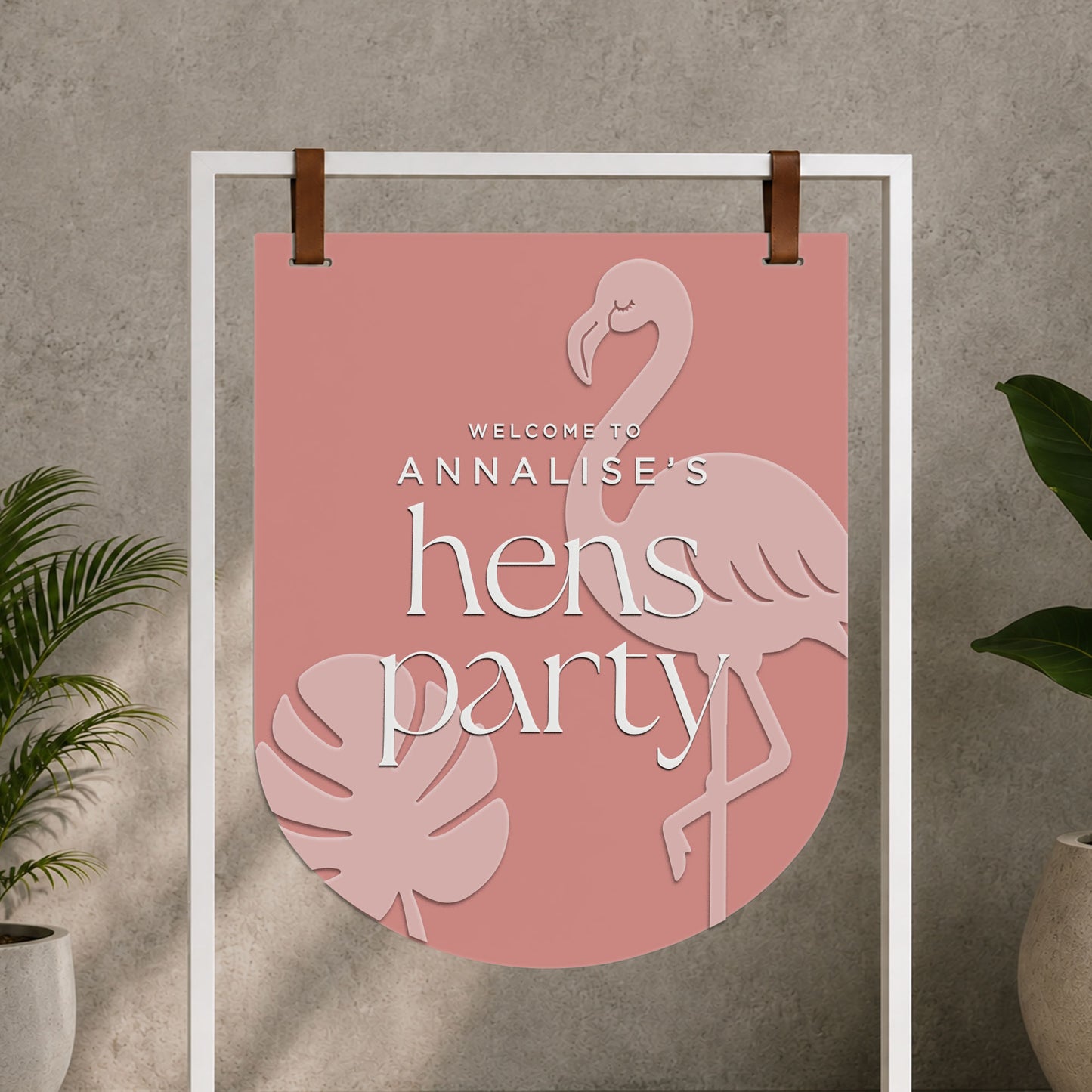 Personalised pink acrylic hens or cocktail party welcome sign with layered flamingo and tropical leaf details.
