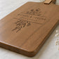 Close-up of a custom charcuterie board featuring detailed floral laser engraving and personalised names on premium acacia timber.