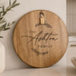Personalised acacia serving board engraved with family name, displayed on a modern kitchen bench with decorative timber tag.