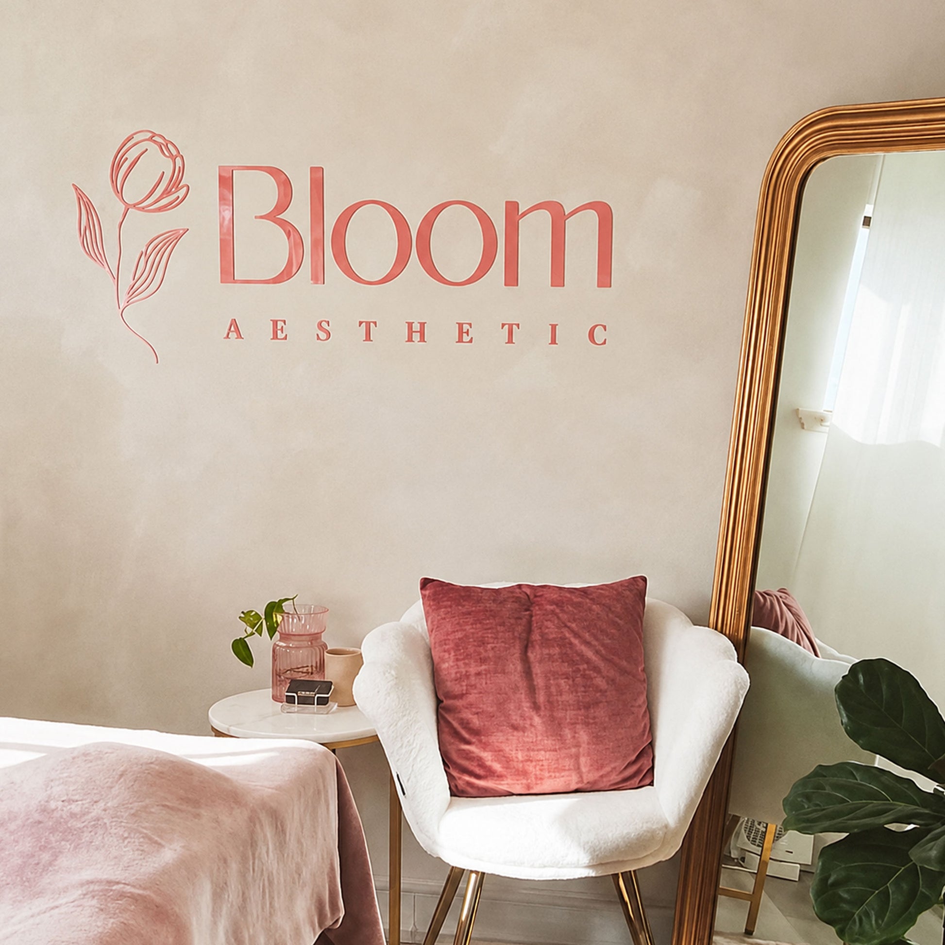 Blush pink acrylic logo sign displayed on the wall of a modern aesthetics clinic with premium custom business branding.