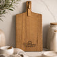 Branded acacia serving board engraved with Wellness on Driftwood business logo displayed in a modern kitchen.