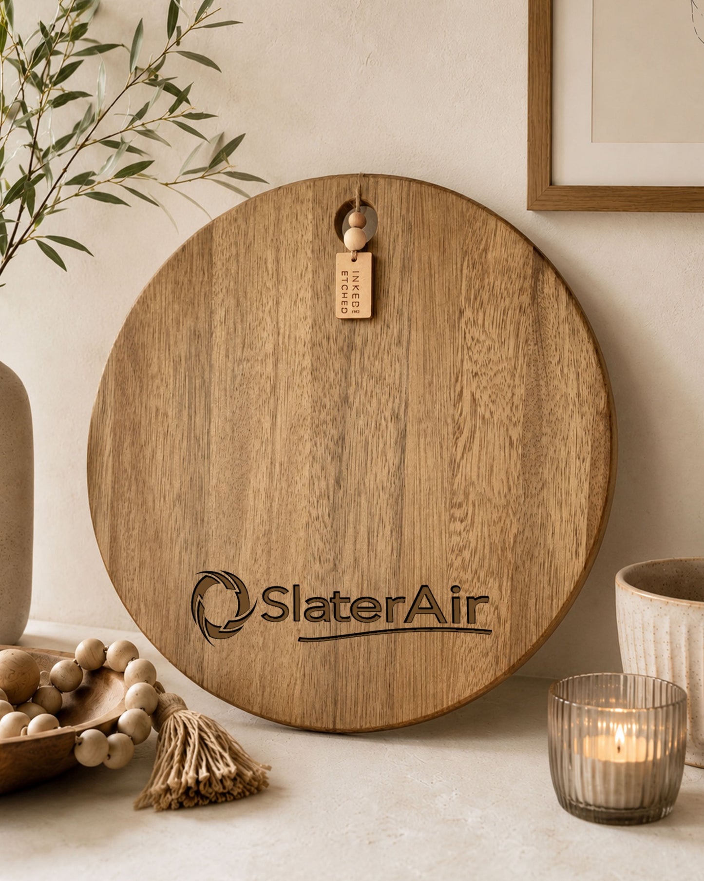 Custom engraved round serving board with the SlaterAir logo styled on a modern kitchen bench.