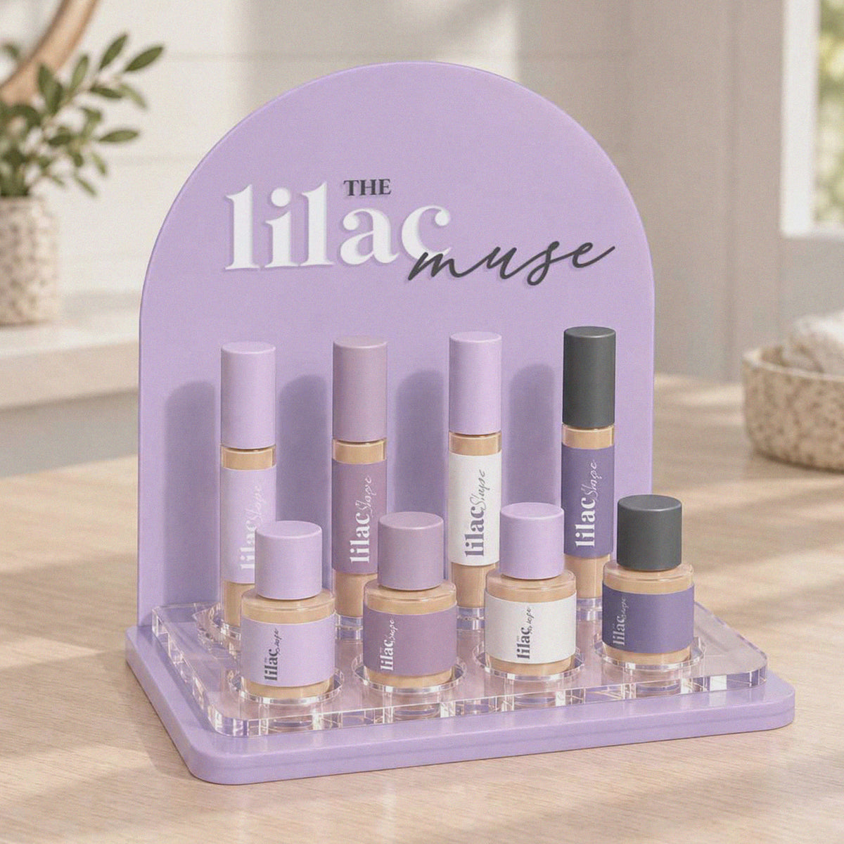 Custom acrylic makeup display stand with logo and eight cosmetic bottle holders.
