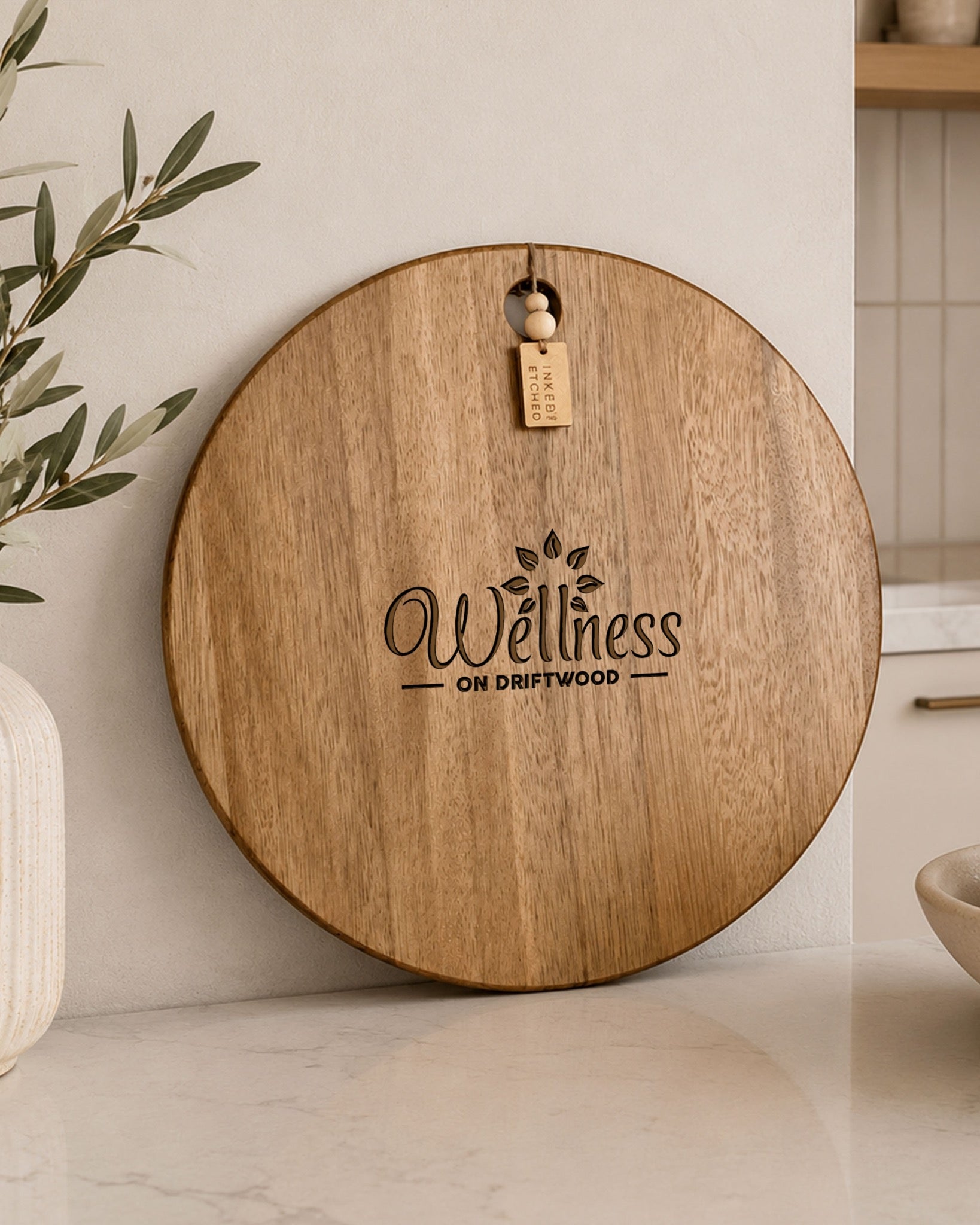Premium round serving board personalised with the Wellness on Driftwood logo for corporate branding.
