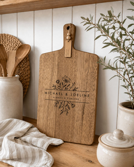 Custom charcuterie board engraved with personalised names displayed in a modern kitchen, handcrafted from premium acacia timber.