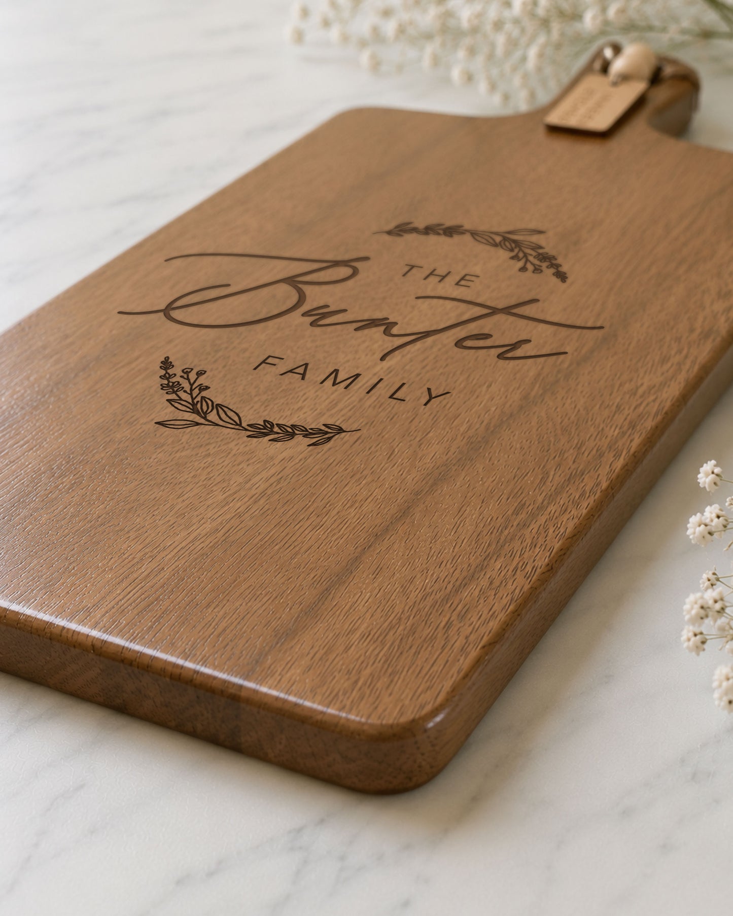 Close-up of a personalised family serving board engraved with a custom surname on premium acacia timber.