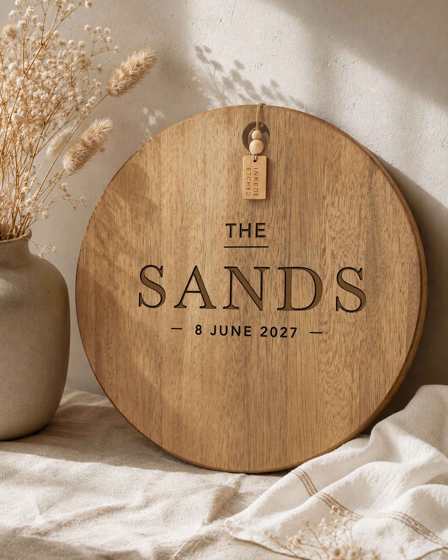 Custom family name serving board engraved with surname and wedding date displayed in a neutral styled home.
