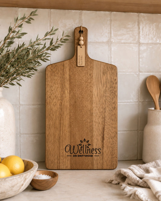 Premium acacia branded serving board with custom business logo styled against tiled kitchen splashback.