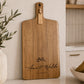 Personalised acacia charcuterie serving board with engraved names displayed in a contemporary kitchen, ideal for entertaining and gifting.