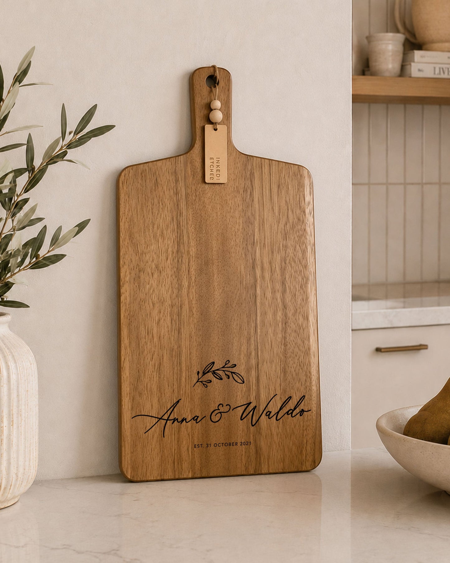 Personalised acacia charcuterie serving board with engraved names displayed in a contemporary kitchen, ideal for entertaining and gifting.