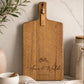 Custom engraved acacia cheese board personalised with names, styled on a marble benchtop as a wedding, anniversary or housewarming gift.