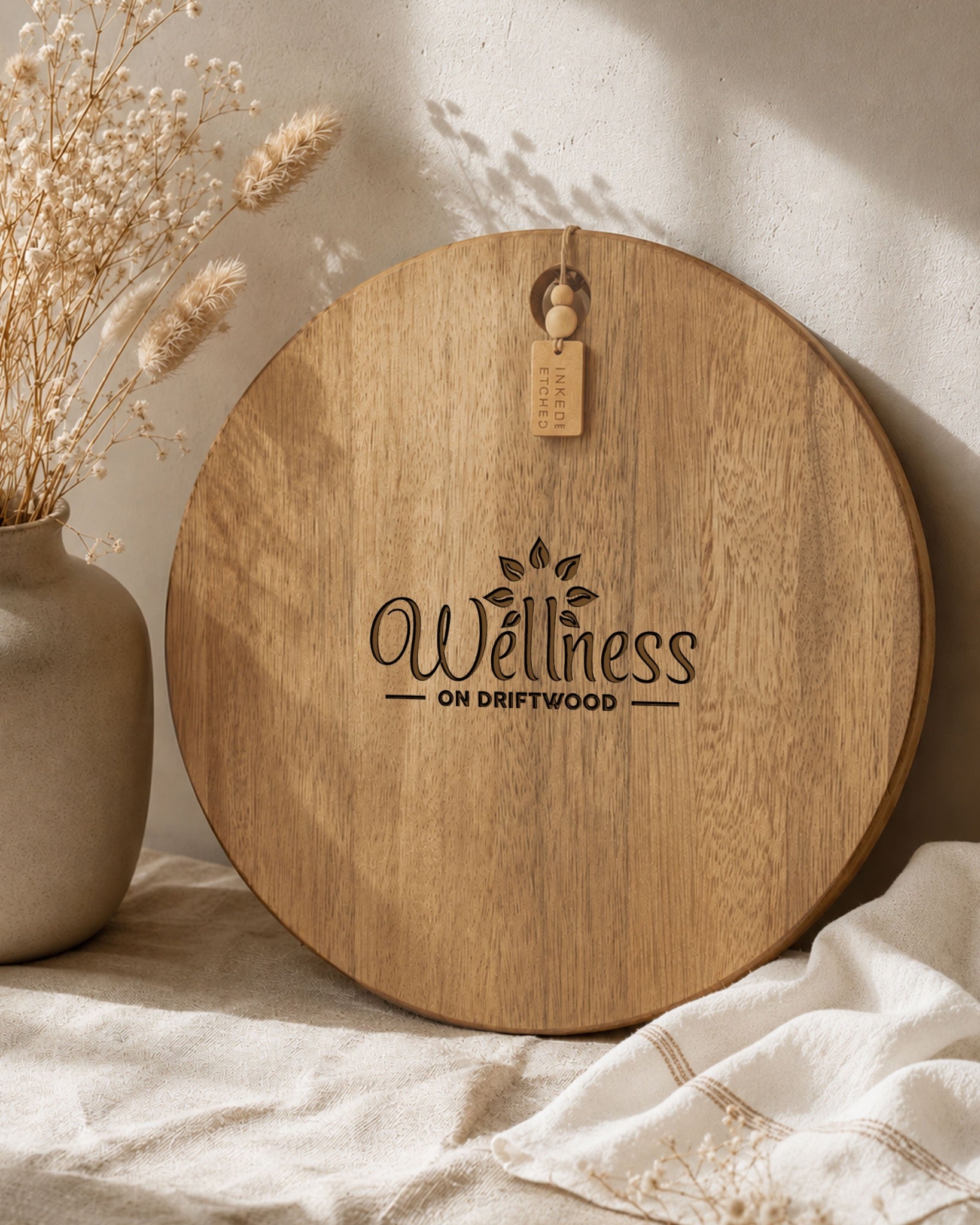 Branded acacia serving board engraved with a business logo, photographed in warm natural light.