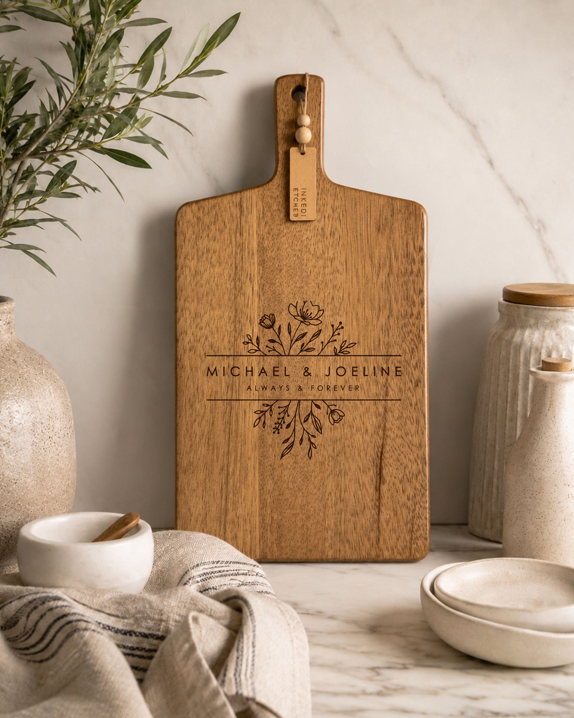 Personalised custom charcuterie board with floral engraving on premium acacia timber styled on a marble kitchen benchtop.