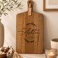 Engraved personalised family cheeseboard made from acacia timber styled in a contemporary kitchen.