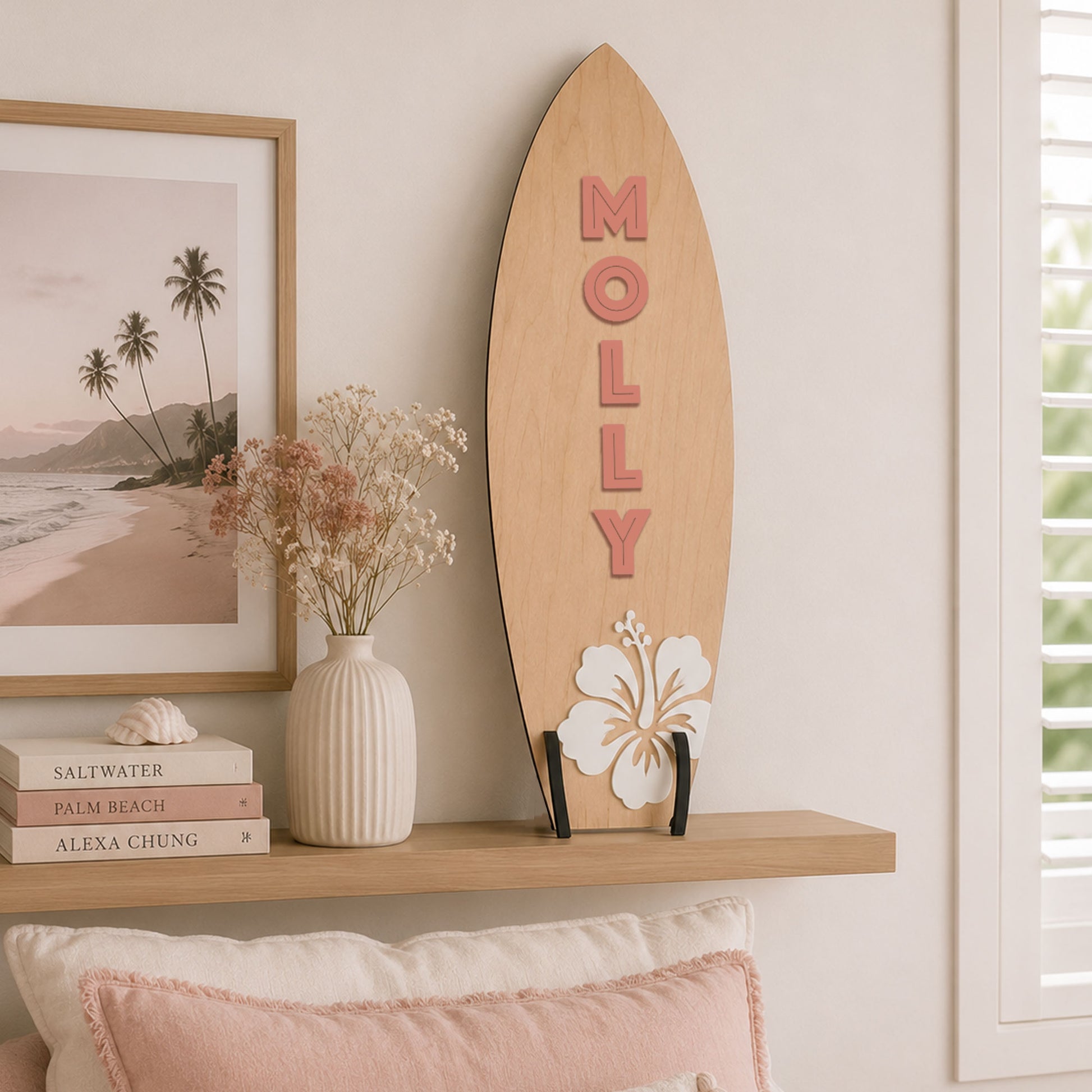 Large personalised wooden surfboard wall decor with hibiscus flower displayed on a shelf in a coastal style children's bedroom.