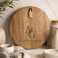 Personalised acacia serving board engraved with couple names displayed in a modern kitchen.