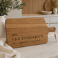 Personalised chopping board engraved with family name on premium acacia timber, displayed on a modern kitchen benchtop with neutral décor.