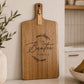 Personalised engraved acacia serving board displayed in a modern kitchen with custom family name engraving.