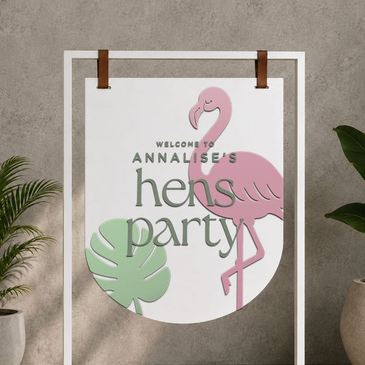 Personalised flamingo acrylic hen party welcome sign with tropical leaf design and layered lettering.