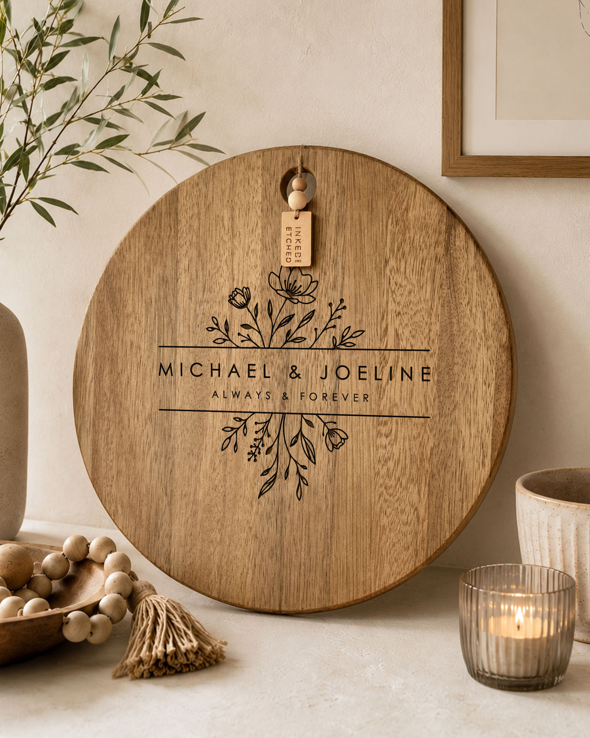 Round personalised floral cheeseboard with engraved names styled as a decorative serving board in a modern home.