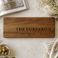 Personalised acacia serving platter engraved with a family name and custom message displayed on a modern kitchen countertop.