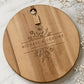 Personalised wedding cheeseboard engraved with floral design and custom names on a round acacia serving board.