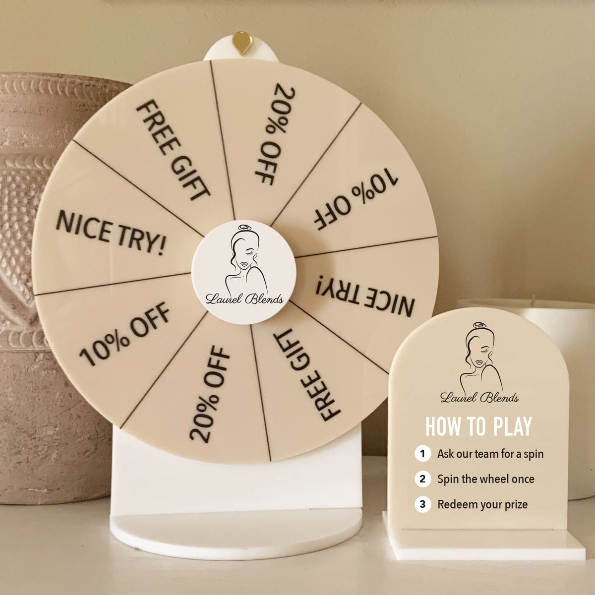 Printed beige Spin The Wheel with Laurel Blends logo and prize segments, displayed with matching Spin To Win sign.