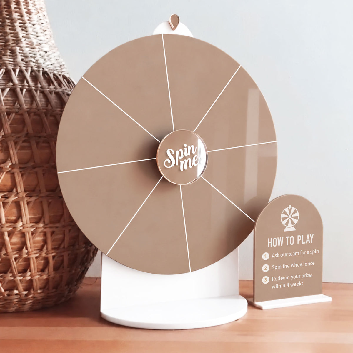Brown acrylic Spin The Wheel with white section lines, a white stand, “Spin Me” centre and matching blank mini sign with instructions.