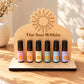 Wooden essential oil display stand holding six 10ml aromatherapy roller bottles on a wooden tabletop.